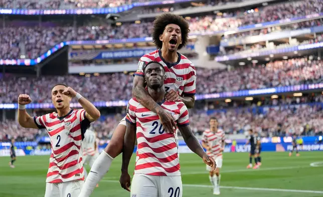 United States' Folarin Balogun (20) celebrates scoring his side's third goal against Paraguay with teamates during the World Cup Group D soccer match in Inglewood, Calif., near Los Angeles, Friday, June 12, 2026. (AP Photo/Andre Penner)