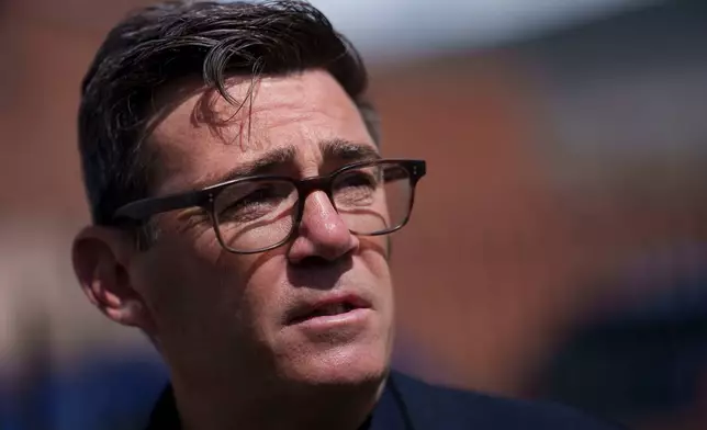 Andy Burnham speaks with police personnel during a campaign visit to the town of Ashton-in-Makerfield before the forthcoming Makerfield by-election, in Greater Manchester, England, Tuesday, June 9, 2026. (AP Photo/Jon Super)
