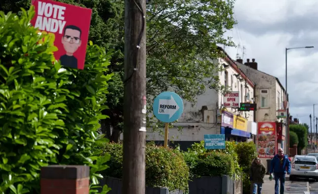 Campaign posters for Andy Burnham and the Reform UK party are displayed in the town of Ashton-in-Makerfield before the forthcoming Makerfield by-election, in Greater Manchester, England, Tuesday, June 9, 2026. (AP Photo/Jon Super)