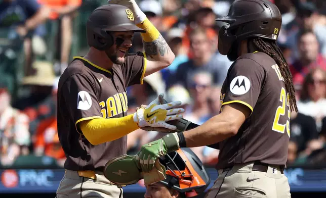 San Diego Padres center fielder Jackson Merrill celebrates with San Diego Padres second baseman Fernando Tatis Jr. after hitting a home run during the first inning of a baseball game against the Baltimore Orioles, Saturday, June 13, 2026, in Baltimore. (AP Photo/Daniel Kucin Jr.)