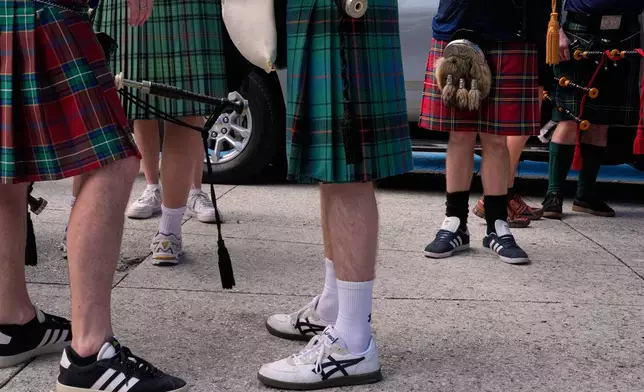 Scotland soccer fans with bagpipes wear kilts as they wait to enter the stadium for a Miami Marlins against the Texas Rangers baseball game after marching with the Tartan Army, Monday, June 22, 2026, in Miami. (AP Photo/Rebecca Blackwell)
