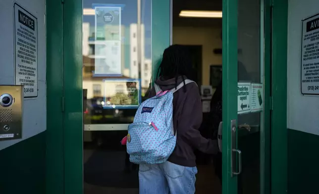 Makeda Walker-Deen, a junior at Susan Miller Dorsey Senior High School, enters the school in Los Angeles, Thursday, May 14, 2026. (AP Photo/Jae C. Hong)