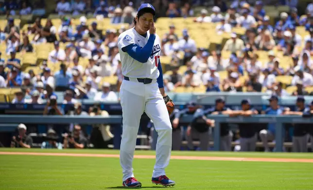 Los Angeles Dodgers starting pitcher Shohei Ohtani wipes his face during the first inning of a baseball game against the Tampa Bay Rays in Los Angeles, Wednesday, June 17, 2026. (AP Photo/Kyusung Gong)