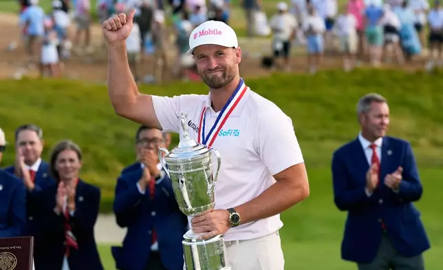 Wyndham Clark holds the trophy after winning the U.S. Open golf tournament at Shinnecock Hills Golf Club in Southampton, N.Y., Sunday, June 21, 2026. (AP Photo/David J. Phillip)
