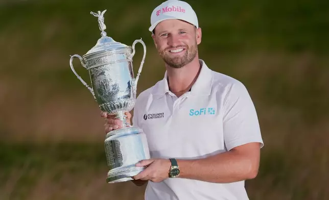 Wyndham Clark holds the trophy after winning the U.S. Open golf tournament at Shinnecock Hills Golf Club in Southampton, N.Y., Sunday, June 21, 2026. (AP Photo/David J. Phillip)