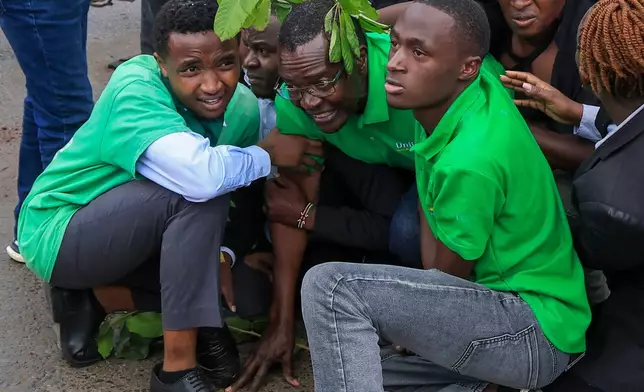 Kenya's former chief justice and presidential contender David Maraga, center, is shielded by protesters in Nairobi, Kenya, Monday, June 8, 2026, during a protest over plans affecting Nairobi National Park. (AP Photo/Andrew Kasuku)