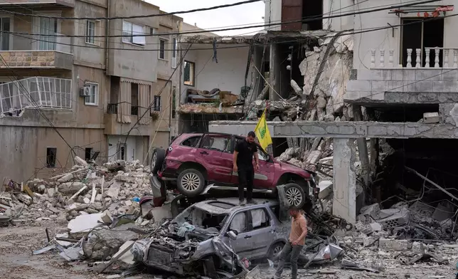People check destroyed cars following a ceasefire between Israel and Hezbollah in the village of Maifadoun, southern Lebanon, Monday, June 22, 2026. (AP Photo/Mohammed Zaatari)