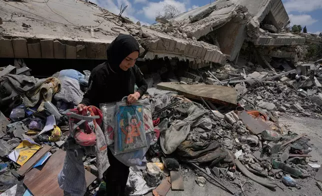 A woman collects her kids toys and belongings from her destroyed house following a ceasefire between Israel and Hezbollah in the village of Maifadoun, southern Lebanon, Monday, June 22, 2026. (AP Photo/Mohammed Zaatari)