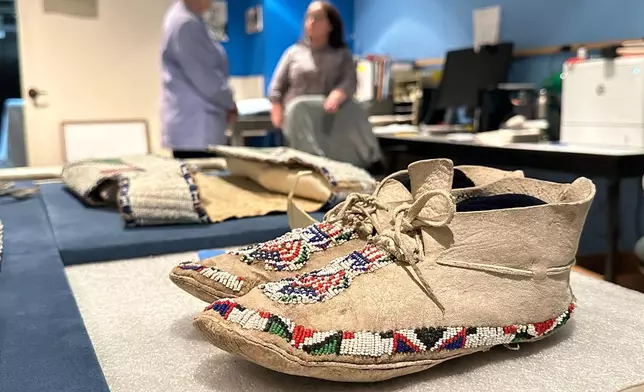 Decades-old moccasins from Taos Pueblo that feature red, white and blue beads are prepared for display as part of the "Stars, Stripes and First Americans" exhibition at the Museum of Indian Arts and Culture in Santa Fe, N.M., on Monday, May 11, 2026. (AP Photo/Susan Montoya Bryan)