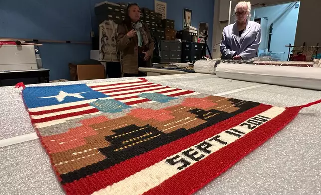 Museum executive director Danyelle Means, left, and head of curatorial affairs Elisa Phelps discuss a weaving by Navajo artist Pauline Thomas as it's prepared for display at the Museum of Indian Arts and Culture in Santa Fe, N.M., on Monday, May 11, 2026. (AP Photo/Susan Montoya Bryan)