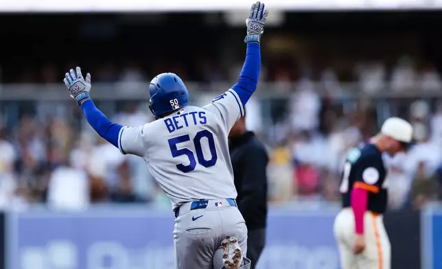 Los Angeles Dodgers' Mookie Betts celebrates as he runs the bases after hitting a solo home run against the San Diego Padres in the first inning of a baseball game, Friday, June 26, 2026, in San Diego. (AP Photo/Derrick Tuskan)
