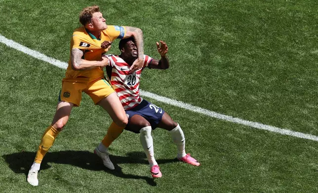 Australia's Harry Souttar (19) and United States' Folarin Balogun (20) grapple during the World Cup Group D soccer match between the United States and Australia in Seattle, Friday, June 19, 2026. (AP Photo/Maddy Grassy)