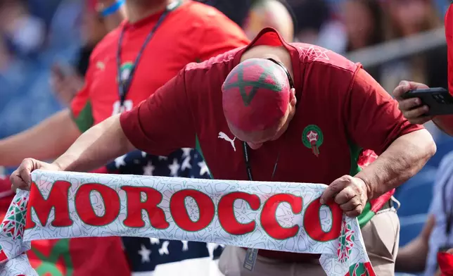 A fan holds a Morocco scarf prior to the World Cup Group C soccer match between Scotland and Morocco in Foxborough, Mass., near Boston, Friday, June 19, 2026. (AP Photo/Martin Meissner)