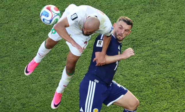 Scotland's John McGinn (7) and Morocco's Noussair Mazraoui (3) battle for the ball during the World Cup Group C soccer match between Scotland and Morocco in Foxborough, Mass., near Boston, Friday, June 19, 2026. (AP Photo/Mark Stockwell)