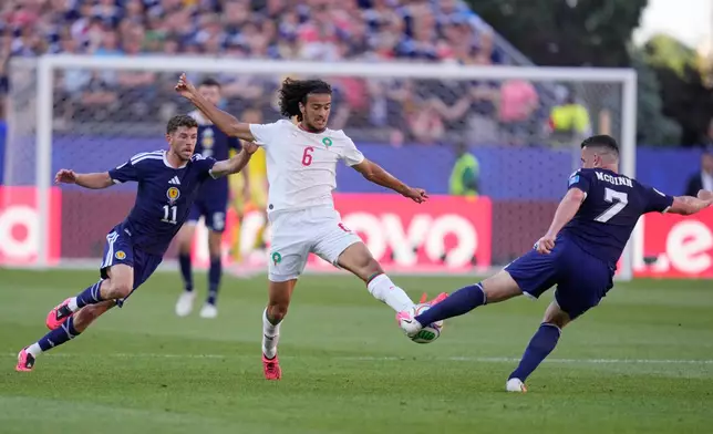 Morocco's Ayyoub Bouaddi, centre, lunges for the ball with Scotland's John McGinn during the World Cup Group C soccer match between Scotland and Morocco in Foxborough, Mass., near Boston, Friday, June 19, 2026. (AP Photo/Charles Krupa)