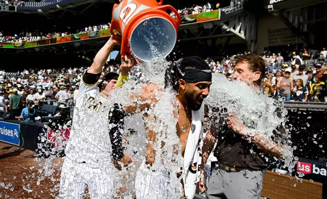 San Diego Padres' Fernando Tatis Jr. has a cooler dumped over him by Ty France after he hit a walk-off home run during a baseball game against the Cincinnati Reds, Wednesday, June 10, 2026, in San Diego. (AP Photo/Denis Poroy)