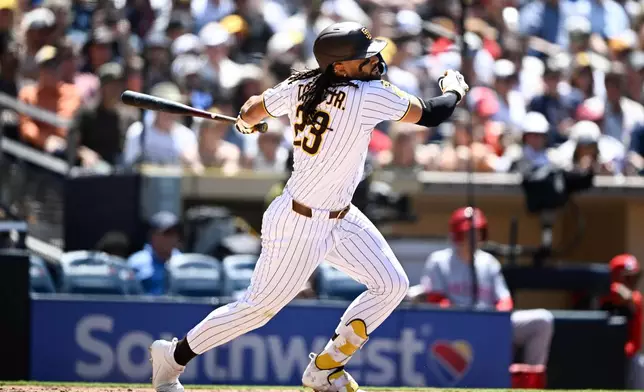 San Diego Padres' Fernando Tatis Jr. (23) hits an RBI single during the fifth inning of a baseball game against the Cincinnati Reds, Wednesday, June 10, 2026, in San Diego. (AP Photo/Denis Poroy)