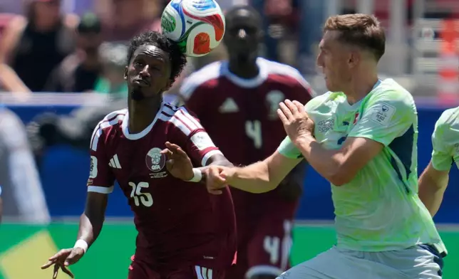 Qatar's Yusuf Abdurisag, left, and Switzerland's Michel Aebischer fight for the ball during the World Cup Group B soccer match between Qatar and Switzerland in Santa Clara, Calif., near San Francisco, Saturday, June 13, 2026. (AP Photo/Eugene Hoshiko)