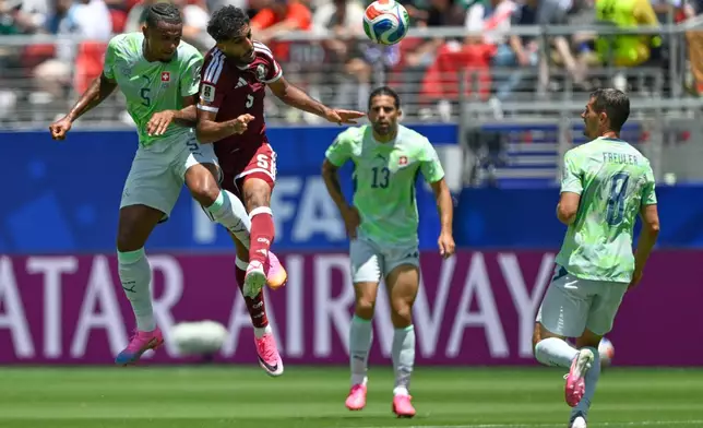 Switzerland's Manuel Akanji, left leaps to head the ball with Qatar's Jassem Gaber, during the World Cup Group B soccer match between Qatar and Switzerland in Santa Clara, Calif., near San Francisco, Saturday, June 13, 2026. (AP Photo/Eakin Howard)