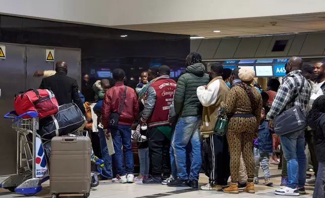 Ghanaian nationals queue with their luggage at O.R. Tambo International Airport as they prepare to board a repatriation flight home following unrest concerns in Johannesburg, South Africa, Wednesday, May 27, 2026. (AP Photo/Kayleen Morgan)