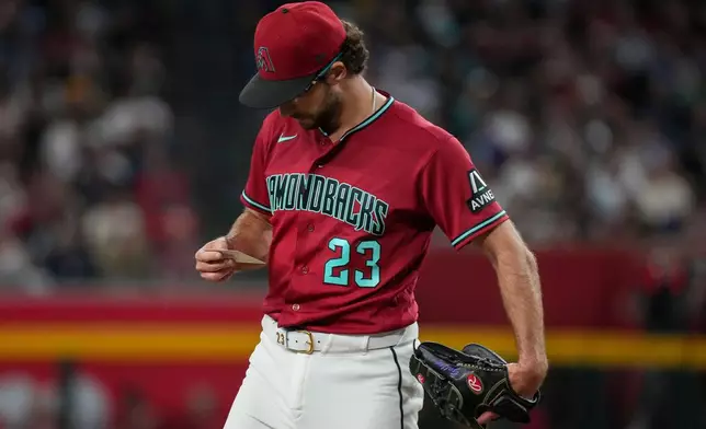 Arizona Diamondbacks pitcher Zac Gallen looks at his line up card against the Minnesota Twins during the first inning of a baseball game Saturday, June 20, 2026, in Phoenix. (AP Photo/Darryl Webb)