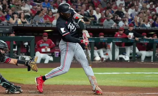 Minnesota Twins' Byron Buxton, right, hits a grand slam in the fifth inning against the Arizona Diamondbacks during a baseball game Saturday, June 20, 2026, in Phoenix. (AP Photo/Darryl Webb)