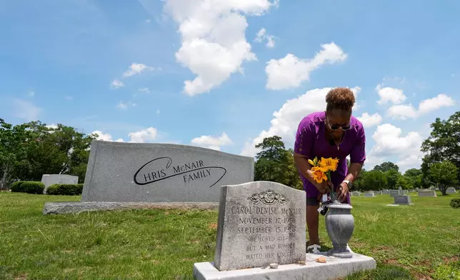 Lisa McNair arranges flowers on the grave of her late sister, Carol Denise McNair, Monday, June 1, 2026, in Birmingham, Ala. (AP Photo/Mike Stewart)