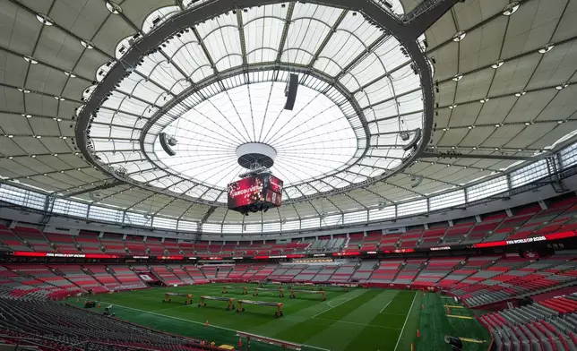 Workers tend to the grass field that has been installed in B.C. Place stadium for the World Cup soccer tournament, Monday, June 8, 2026, in Vancouver, British Columbia. (Darryl Dyck/The Canadian Press via AP)