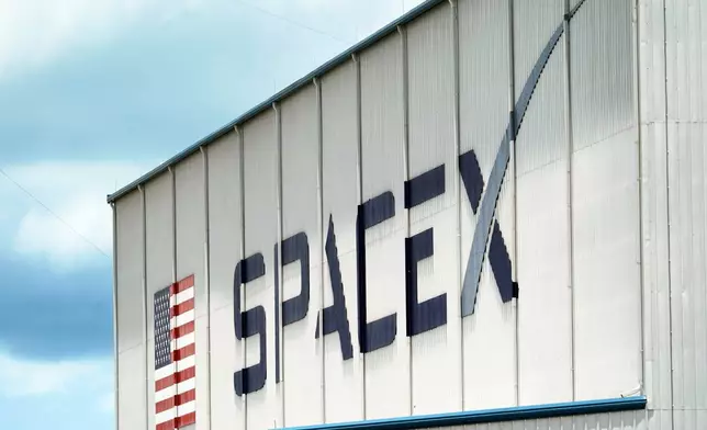 FILE - A SpaceX logo is displayed on a building, May 26, 2020, at the Kennedy Space Center in Cape Canaveral, Fla. (AP Photo/David J. Phillip, File)