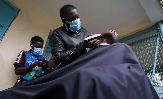 Barbers shave patients hair during a grooming session at the largest mental health referral hospital, Mathari in Nairobi, Kenya, Tuesday, June 30, 2026. (AP Photo/Andrew Kasuku)
