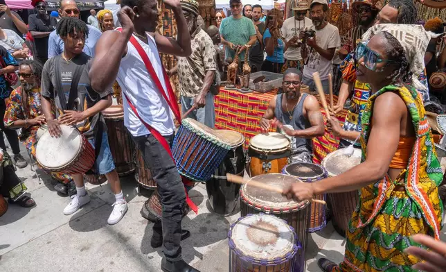FILE - Drummers form a circle around Sika Dwimfo, better known as the, "Godfather of Leimert Park," during the neighborhood's Juneteenth celebration, June 19, 2024, at Leimert Park in Los Angeles. (AP Photo/Damian Dovarganes, File)