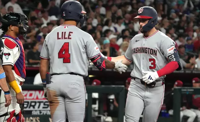 Washington Nationals' Dylan Crews celebrates with Daylen Lile (4) after hitting a solo home run against the Arizona Diamondbacks in the seventh inning of a baseball game, Saturday, June 6, 2026, in Phoenix. (AP Photo/Rick Scuteri)