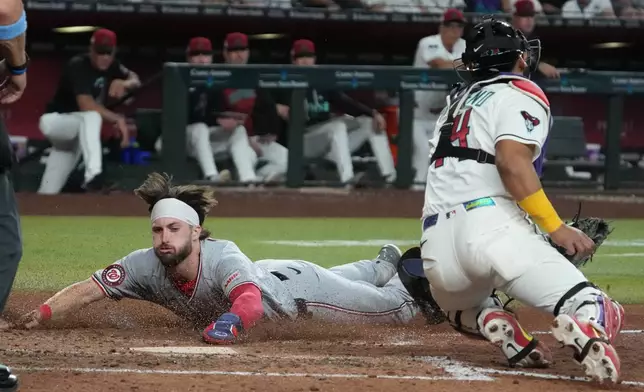 Washington Nationals' Dylan Crews scores a run against the Arizona Diamondbacks on a ball hit by Nasim Nuñez in the ninth inning of a baseball game, Saturday, June 6, 2026, in Phoenix. (AP Photo/Rick Scuteri)
