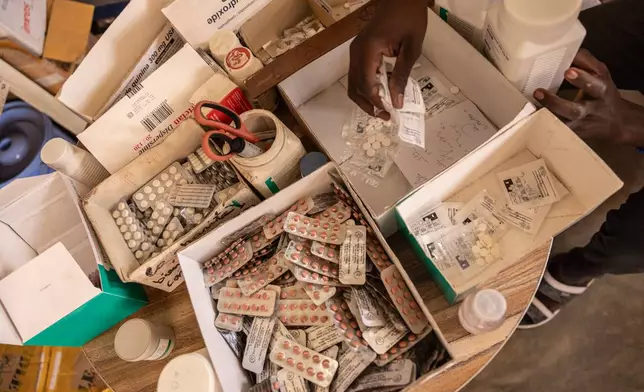 A pharmacist hands pregnant women painkillers from boxes at the pharmacy of the Birao District Hospital in the Central African Republic, Thursday, March 26, 2026. (AP Photo/Caitlin Kelly)