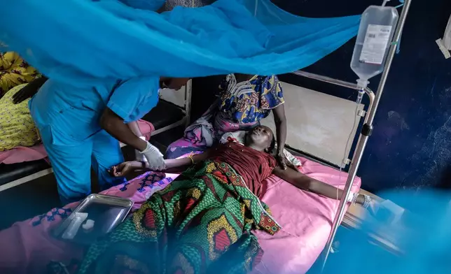 A nurse gives painkillers to patient Amna Adam Hessen, whose baby was delivered stillborn the previous day, at the Birao District Hospital in the Central African Republic, Wednesday, March 25, 2026. (AP Photo/Caitlin Kelly)
