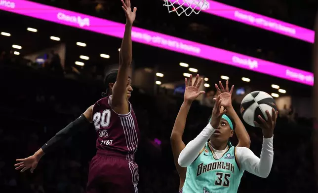New York Liberty center Jonquel Jones (35) goes up for a shot against Toronto Tempo guard Brittney Sykes (20) during the first half of a WNBA basketball game, Wednesday, June 3, 2026, in New York. (AP Photo/Heather Khalifa)