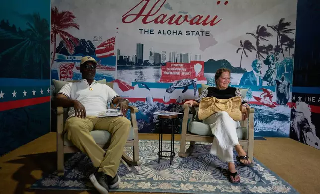 Alonzo Lewis Jr, and Kelly Domizio sit in cushy chairs in Hawaii's exhibit during the Great American State Fair on Friday, June 26, 2026, in Washington. (AP Photo/Carolyn Kaster)
