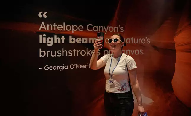 Natalia Romanova from Kazakstan uses a smartphone in Arizona's interactive exhibit during the Great American State Fair on Friday, June 26, 2026, in Washington. (AP Photo/Carolyn Kaster)