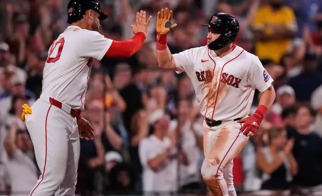 Boston Red Sox's Caleb Durbin, right, is congratulated by Willson Contreras after his two-run home run off New York Yankees' Cam Schlittler in the fifth inning of a baseball game, Thursday, June 25, 2026, in Boston. (AP Photo/Charles Krupa)