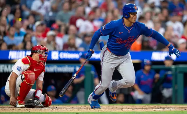 New York Mets' Juan Soto, right, starts to run after hitting a single during the third inning of a baseball game against the Philadelphia Phillies, Saturday, June 20, 2026, in Philadelphia. (AP Photo/Chris Szagola)