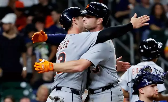 In a repeat of the third inning, Detroit Tigers' Dillon Dingler, center left, and Colt Keith, center right, hug at the plate after they both scored on the two-run home run by Keith against the Houston Astros during the seventh inning of a baseball game Monday, June 15, 2026, in Houston. (AP Photo/Michael Wyke)