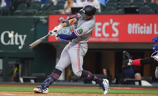 Minnesota Twins' Brooks Lee, left, hits a home run in front of Texas Rangers catcher Kyle Higashioka during the first inning of a baseball game against the Texas Rangers, Thursday, June 18, 2026, in Arlington, Texas. (AP Photo/LM Otero)