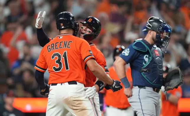 Detroit Tigers' Spencer Torkelson celebrates his two-run home run with Riley Greene (31) as Seattle Mariners catcher Mitch Garver, right, looks on during the eighth inning of a baseball game Friday, June 5, 2026, in Detroit. (AP Photo/Paul Sancya)