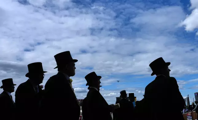 Racegoers are silhouetted as they follow the action on the first day of the Royal Ascot horse race meeting in Ascot, England, Tuesday, June 16, 2026.(AP Photo/Kin Cheung)