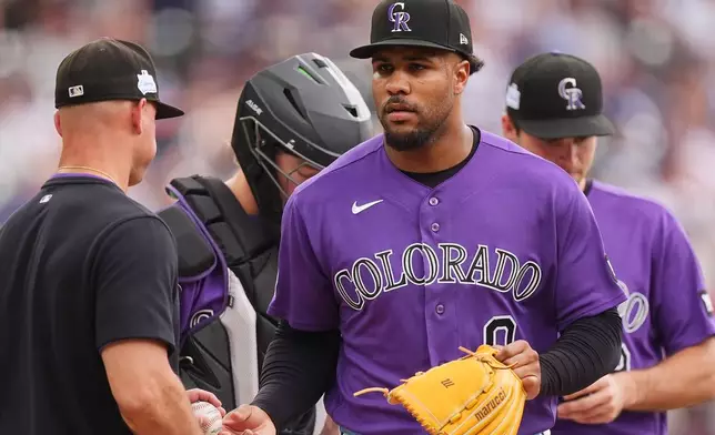 Colorado Rockies manager Warren Schaeffer, left, takes the ball from relief pitcher Jaden Hill, front right, who is pulled from the mound after giving up a two-run single to Milwaukee Brewers' Brice Turang in the sixth inning of a baseball game Sunday, June 7, 2026, in Denver. (AP Photo/David Zalubowski)