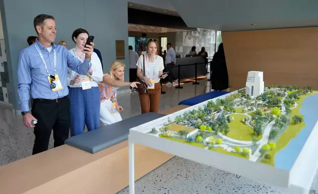 People stop to take a closer look at a scale model of the Obama Presidential Center as they arrive for a stakeholders reception at the Obama Presidential Center, Tuesday, June 16, 2026, in Chicago. (AP Photo/Pablo Martinez Monsivais, Pool)