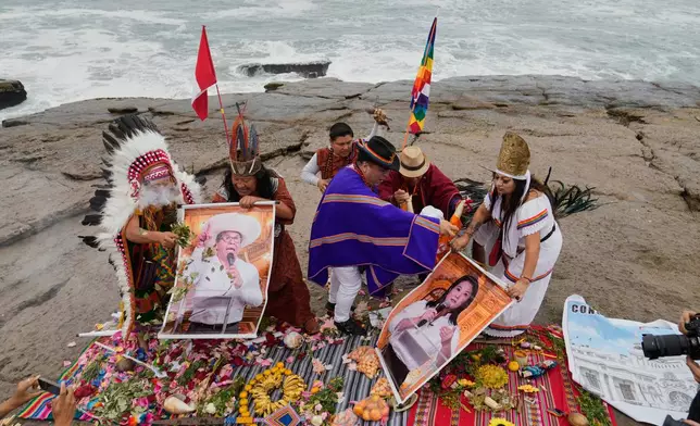 Shamans perform a ritual holding posters of presidential candidate Keiko Fujimori, right, and Roberto Sanchez on Herradura beach in Lima, Peru, Monday, June 1, 2026, ahead of their presidential runoff election. (AP Photo/Martin Mejia)