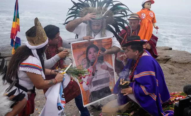 A shaman performs a ritual holding a poster of presidential candidate Keiko Fujimori on Herradura beach in Lima, Peru, Monday, June 1, 2026, ahead of a presidential runoff election. (AP Photo/Martin Mejia)