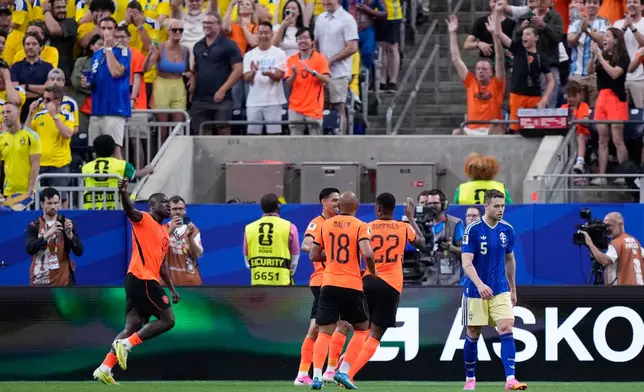 Sweden's Gabriel Gudmundsson, right, reacts as Netherlands' Brian Brobbey, left, celebrates after scoring his side's second goal during the World Cup Group F soccer match between the Netherlands and Sweden in Houston, Saturday, June 20, 2026. (AP Photo/Ashley Landis)
