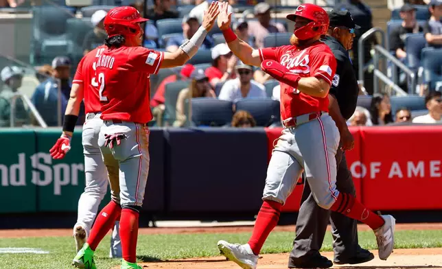 Cincinnati Reds' Edwin Arroyo (2) and Blake Dunn (59) react after scoring during the third inning of a baseball game against the New York Yankees, Saturday, June 20, 2026, in New York. (AP Photo/Noah K. Murray)